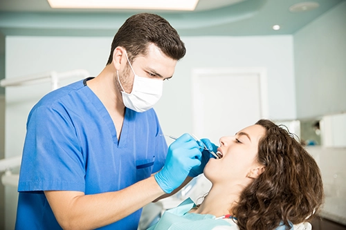 Médico atendiendo a paciente joven en su clínica dental de Getafe