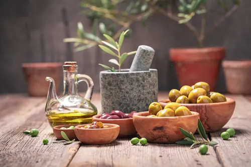 Aceite de oliva y aceitunas presentados en un ambiente rústico