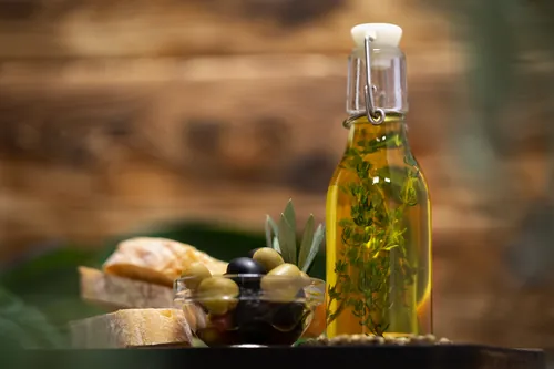 Aceite de oliva servido con pan y aceitunas para mojar