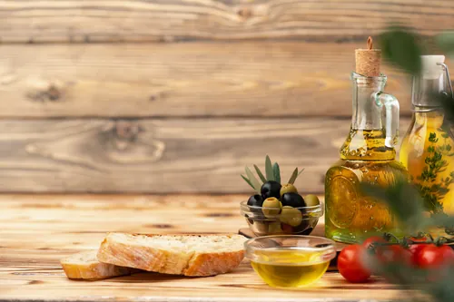 Aceite aceitunas pan y tomates servidos sobre la mesa