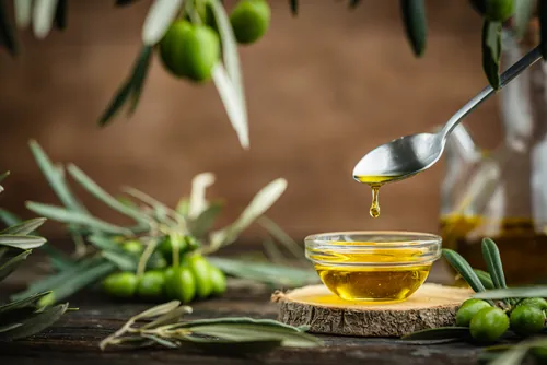 Aceite deslizándose desde una cuchara hacia el cuenco