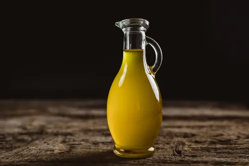 Aceite dorado en una garrafa de cristal sobre madera