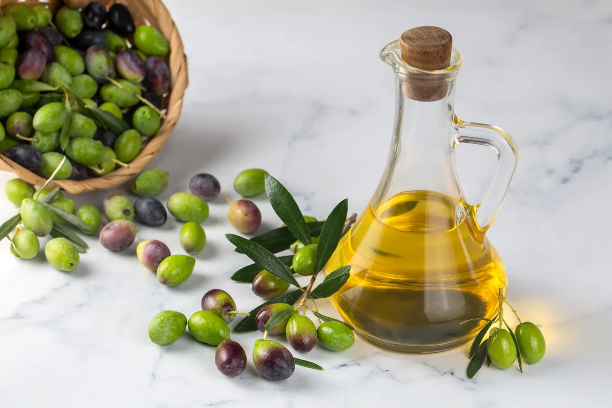 Aceituna verde fresca colocada junto a un poco de aceite