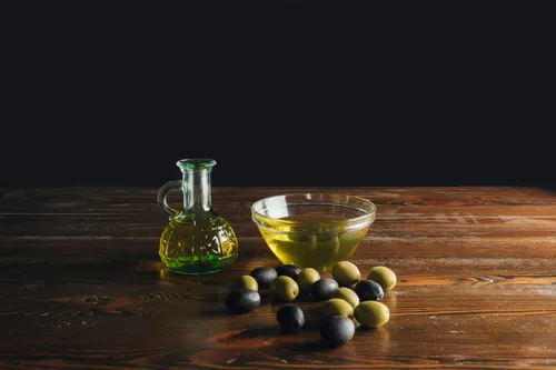 Aceitunas y aceite servidos sobre una tabla de madera