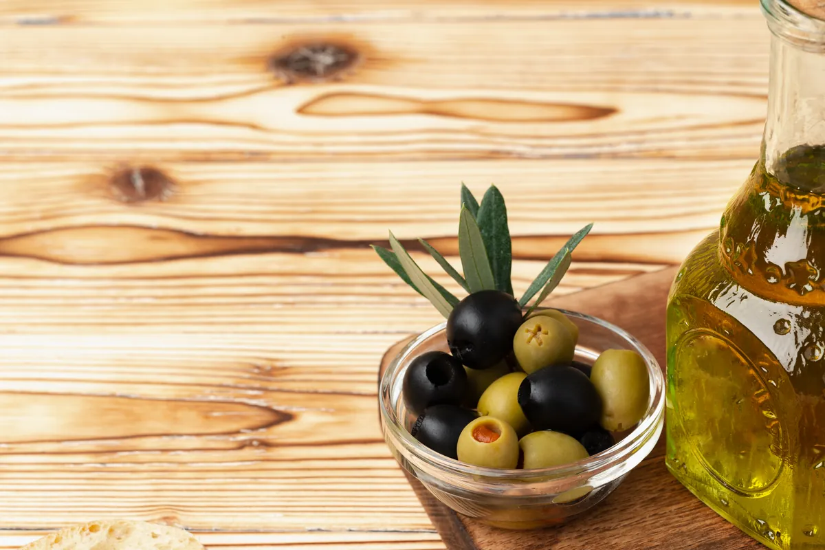 Aceitunas verdes y negras dispuestas junto al aceite