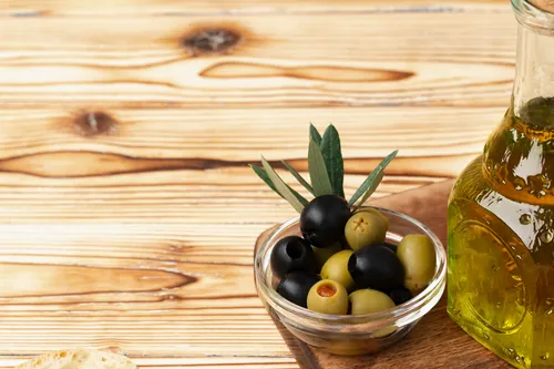Aceitunas verdes y negras dispuestas junto al aceite