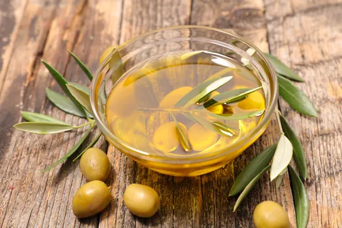 Bodegón con aceite de oliva y aceitunas sobre madera rústica