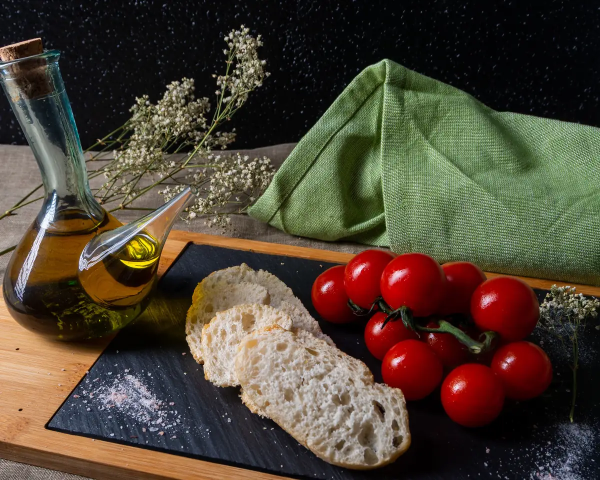 Bodegón compuesto por aceite pan y tomates maduros