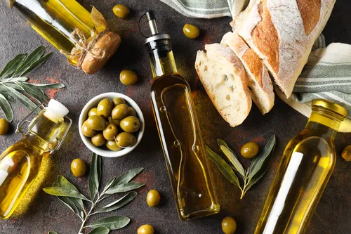 Botellas de aceite de oliva con aceitunas y rebanadas de pan