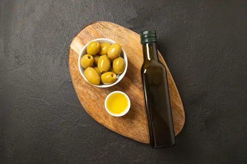 Cuencos de aceite y aceitunas con pan ya rebanado