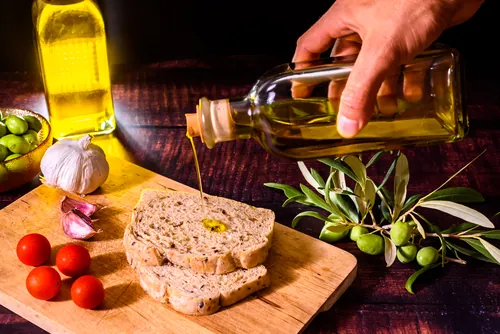 Una mano dejando caer un hilo de aceite