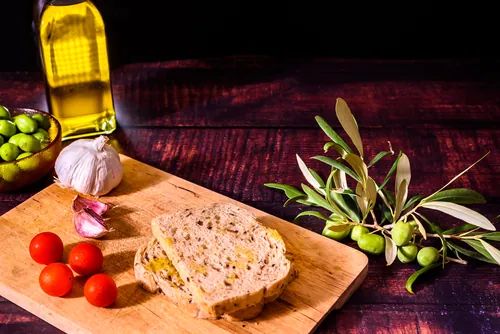 Pan artesano acompañado de aceitunas y ajos sobre el mostrador