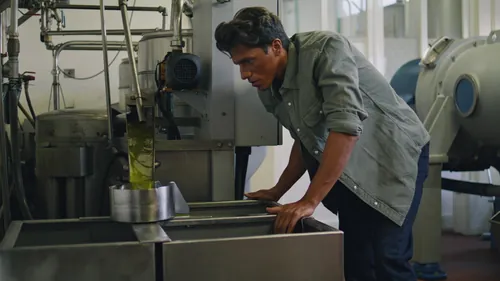 Operario revisando la maquinaria de producción de aceite de oliva