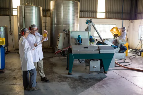 Dos técnicos examinando el aceite obtenido en la fábrica