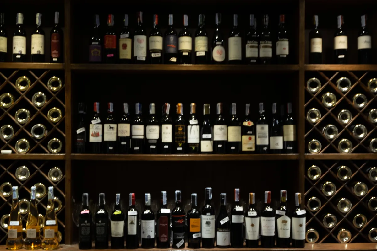 Barra de bar con botellas de vino al fondo desenfocado