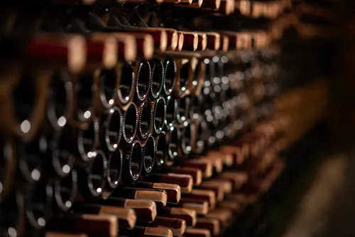 Fila de botellas de vino sobre una balda de madera