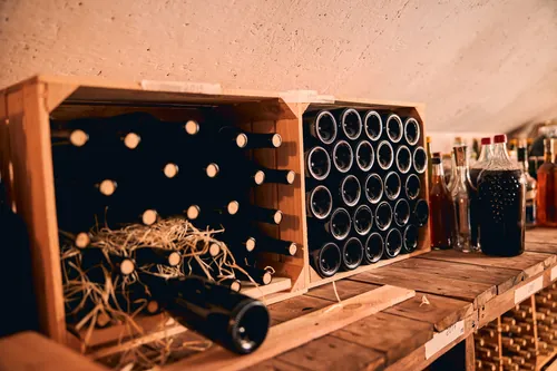 Botellas de vino guardadas dentro de cajas de madera apiladas