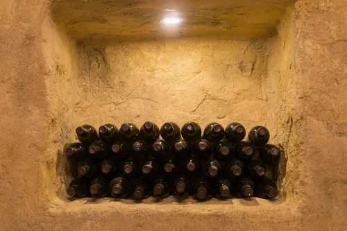 Botellas de vino apiladas en una hornacina de piedra