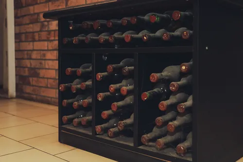 Botellas polvorientas guardadas en un botellero de la bodega