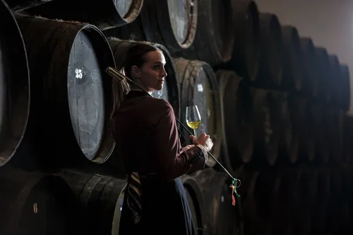Mujer sosteniendo una copa de vino dentro de la bodega