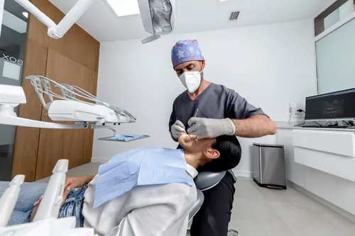 Profesional de pie examinando la boca de un paciente