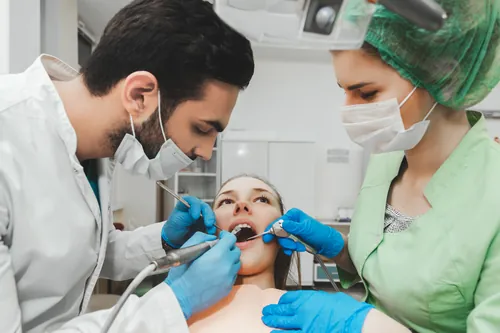 Dos profesionales asistiendo durante la exploración de un paciente