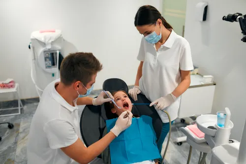 Dos profesionales examinando la dentadura de una niña