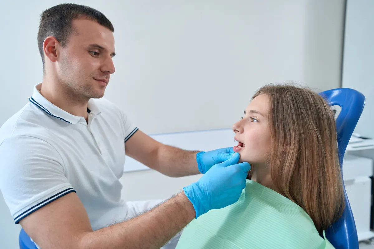 Odontólogo examinando la dentadura de una paciente joven