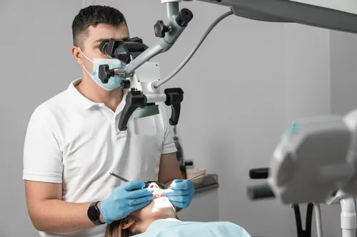 Profesional usando el microscopio sobre un paciente tumbado