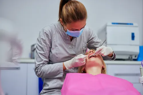 Odontólogo revisando los dientes de una paciente en clínica