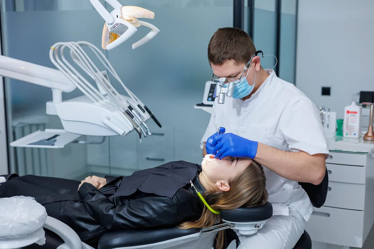 Odontólogo tratando los dientes de un paciente en consulta moderna