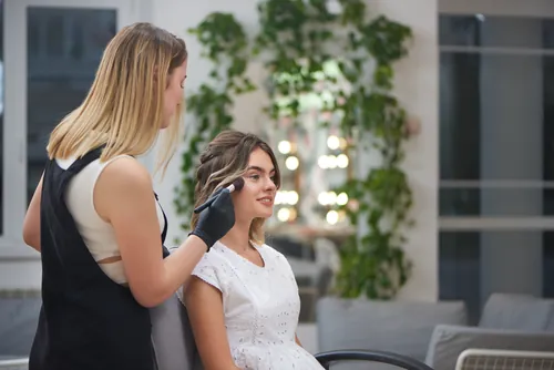 Clienta con el maquillaje siendo aplicado en el interior