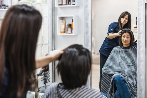 Corte de pelo reflejado en el espejo de la peluquería