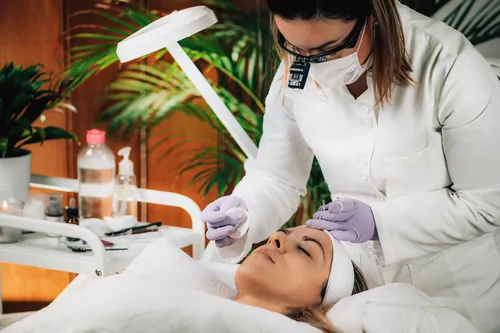 Profesional aplicando un tratamiento facial en su cabina de trabajo