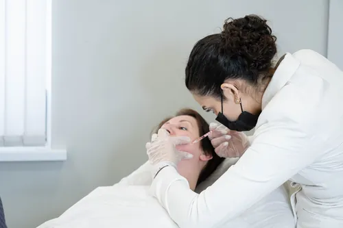 Profesional aplicando una infiltración facial en la consulta clínica