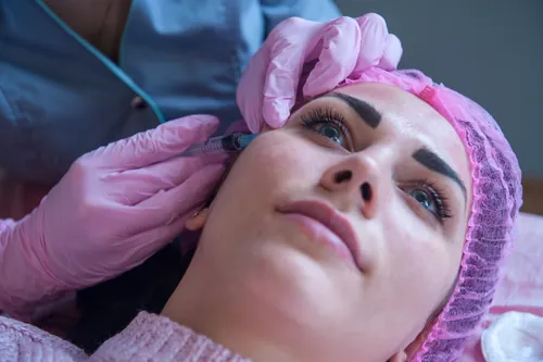 Clienta recibiendo una inyección dentro de un tratamiento cosmético