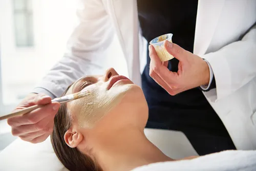 Mujer recibiendo una mascarilla facial suave durante la sesión