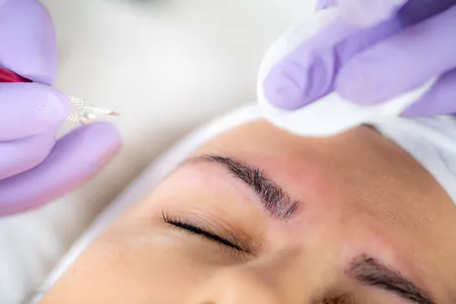 Mujer recibiendo un tratamiento de microblading en las cejas
