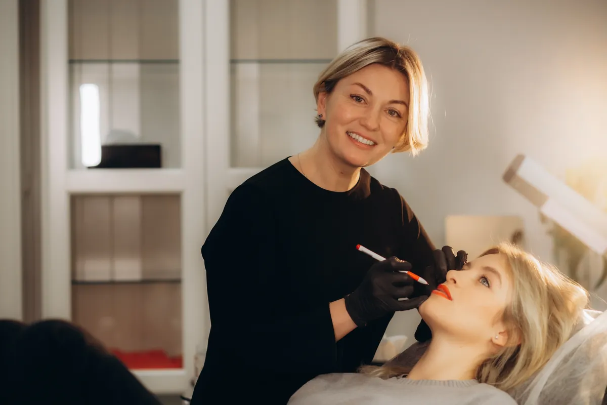 Profesional perfilando los labios de una modelo en cabina