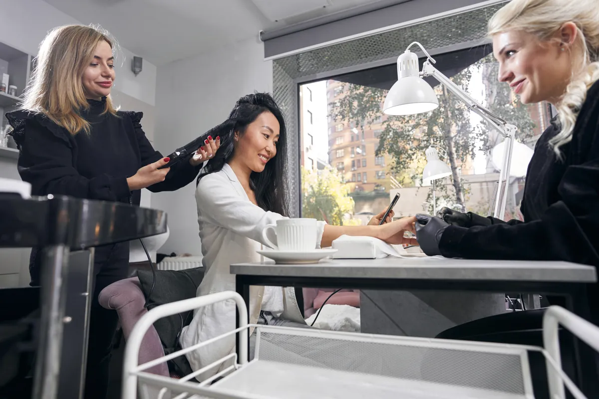 Clientas recibiendo servicios de estética y manicura en el salón
