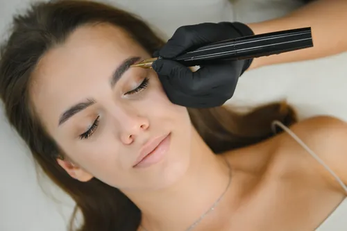 Primer plano de un procedimiento de tatuaje de cejas
