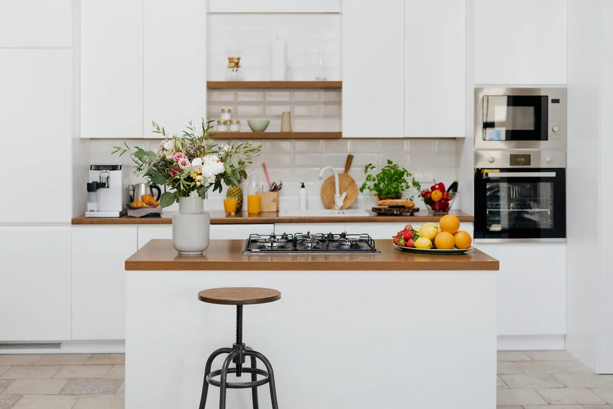 Cocina moderna con fruta fresca y flores sobre la encimera