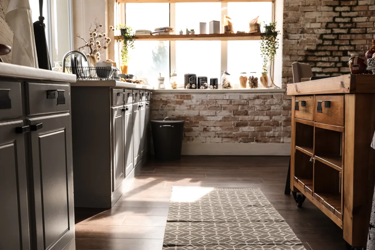 Cocina con pared de ladrillo visto bañada por el sol