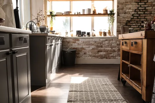 Cocina con pared de ladrillo visto bañada por el sol