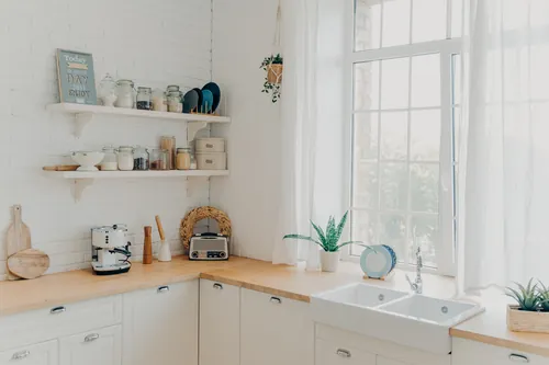 Cocina moderna con armarios blancos y algunos elementos decorativos
