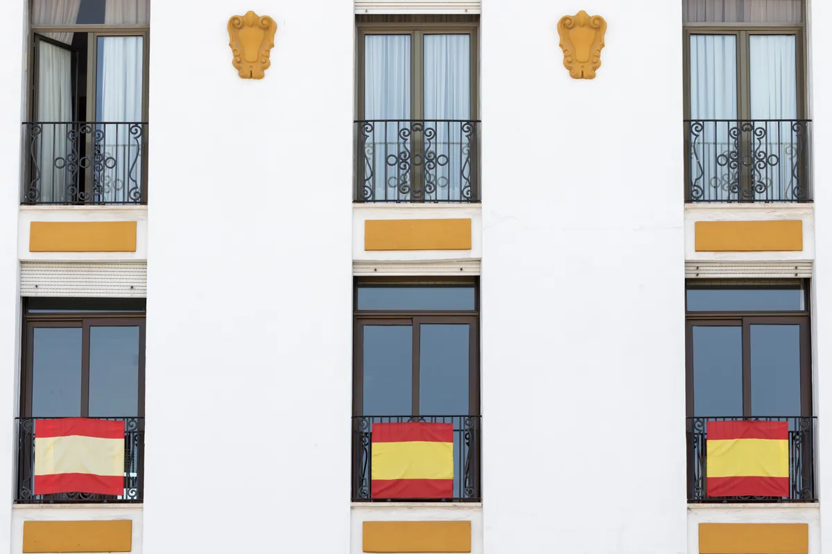 Fachada de un edificio con banderas colgadas de los balcones