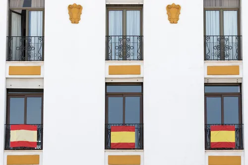Fachada de un edificio con banderas colgadas de los balcones