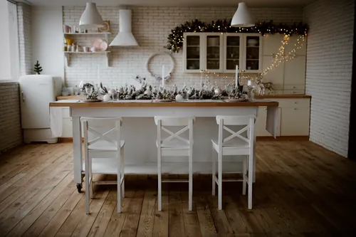 Mesa decorada dentro de una cocina de tonos blancos