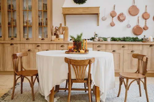 Mesa de comedor decorada con velas y ramas verdes