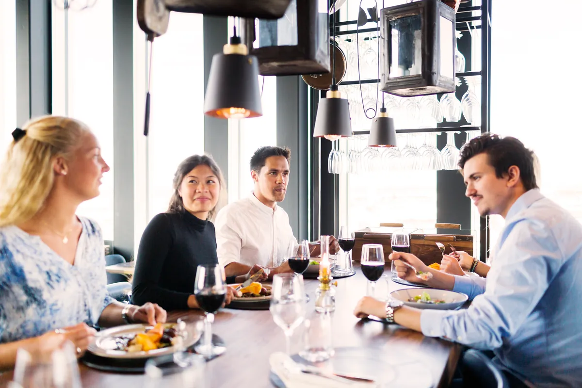 Amigos jóvenes disfrutando de una comida en la mesa